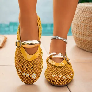 Close-up of yellow fishnet hollow-out flat sandals with gold metallic buckle strap