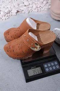 Detailed macro view showing the weight of hollow platform mule shoes on a digital scale