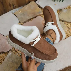 Detail shot of brown winter snow boots with white faux fur lining and white laces