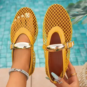 Detailed macro shot of yellow hollow fishnet flat sandals featuring a stylish gold buckle