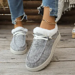 Nahaufnahme grauer Damen-Loafer mit weißem Kunstfellfutter und Schnürsenkeln.