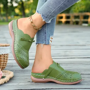 Detailed view of olive green retro platform mules with hollow laser-cut floral patterns