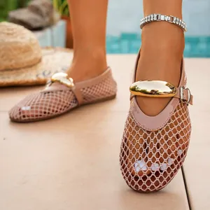 Detailed view of mesh hollow flat sandals featuring a large gold buckle and ankle strap
