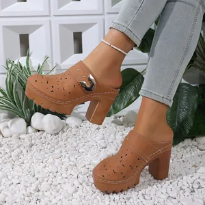 Detailed view of tan platform mules with laser-cut floral patterns and chunky heels