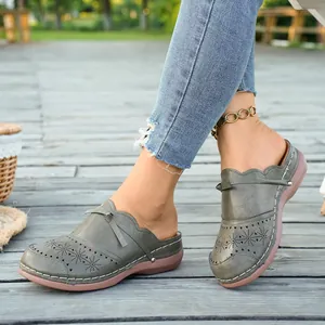 Detail shot of vintage wedge clogs with hollowed-out patterns and decorative stitching.