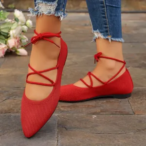 Détail de ballerines élégantes en maille rouge à lacets avec bout pointu et rubans