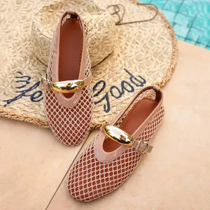 Detail shot of elegant beige mesh hollow-out flat sandals with a stylish gold buckle