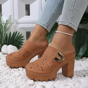 Close-up detail of stylish tan platform mules with laser-cut floral pattern and buckle