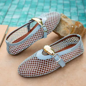 Close-up of light blue mesh flat shoes with decorative gold buckle and hollow-out design.