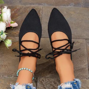 Gros plan sur des ballerines pointues en maille noire avec lacets croisés élégants
