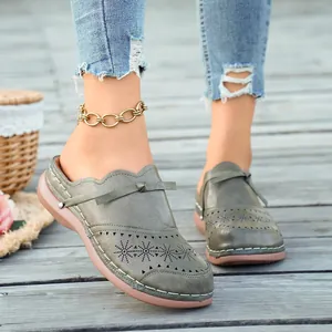 Close-up view of olive green vintage wedge mules with perforated star pattern and bow