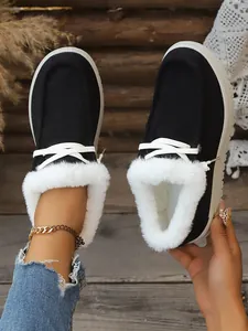 Detailed macro view of black winter snow boots with soft white faux fur lining and laces
