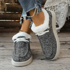Gemütliche graue Damen-Loafer mit weißem Kunstfellfutter auf rustikalem Holzboden