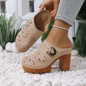 Detailed side view showing the floral cutout texture of beige platform mules with chunky heels.