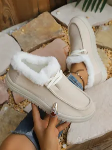 Close-up of beige fur-lined winter boots with comfortable flat soles and soft fleece lining