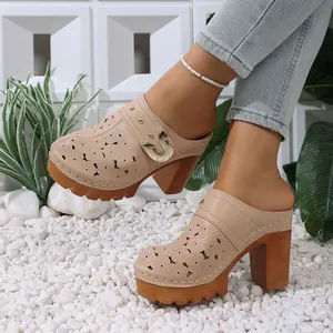 Stylish beige platform mules featuring floral cutouts and gold buckle shown on a model