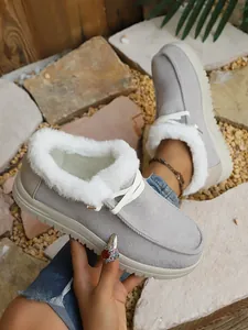 Detailed view of grey fleece-lined snow boots featuring white faux fur lining and laces