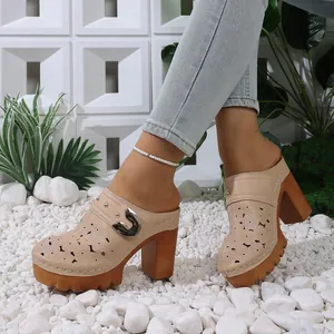 Detail of beige hollow-out platform mules with floral patterns and thick wood heels