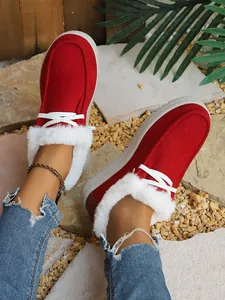 Red corduroy winter snow boots with white faux fur lining shown on-foot in outdoor setting