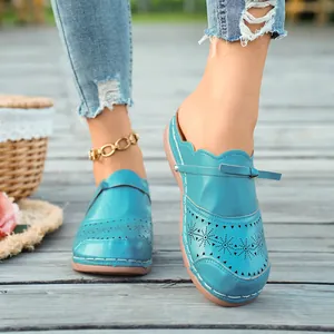 Close-up detail of the intricate star laser-cut patterns on these blue retro wedge mules