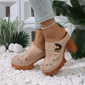 Detailed side view of beige hollowed-out platform mule with thick heel and buckle