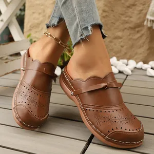 Detail view of brown retro wedge clogs with hollow-out star patterns on a model's feet