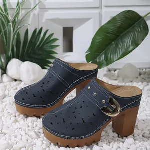Side view showing laser-cut details and gold buckle on navy blue platform mule shoes