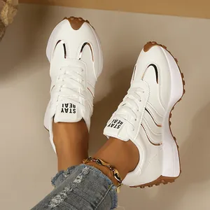 Nahaufnahme von weißen Damen-Sportschuhen mit dicker Sohle und STAY REAL Logo