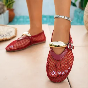 Close-up of red fishnet mesh hollow flat sandals featuring elegant gold buckle