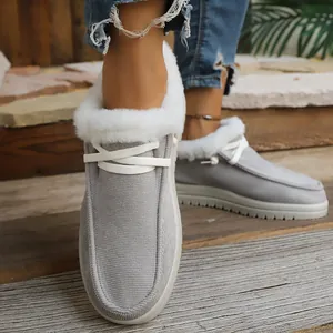 Close-up of women's grey fleece-lined snow boots with white faux fur and laces