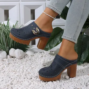 Detailed view of navy blue high heel clogs featuring chunky wooden heels and floral cutouts.