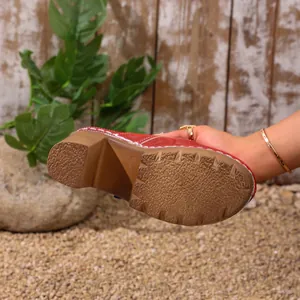 Detailed view showing the textured anti-slip sole of red platform chunky heel mules