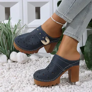 Close-up of navy blue clogs with star cutouts and chunky wooden heels.