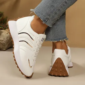 Nahaufnahme weißer Chunky-Sneaker mit brauner Profilsohle und modischen Streifendetails
