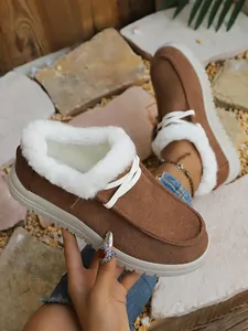 Close-up of brown winter loafers with warm white faux fur lining and platform sole.