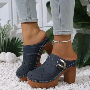 Detailed view of navy blue platform mules with chunky heels and cutout floral patterns