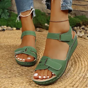 Detailansicht der grünen Plateau-Keilsandalen mit Klettverschluss auf Strohmatte