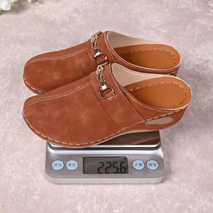 Detail shot of lightweight brown suede wedge mules on a digital scale showing 225.6g