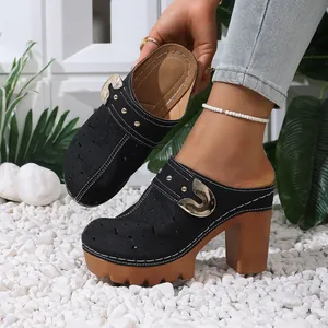 Detail showing the star-patterned hollowed upper and gold buckle of the black mules