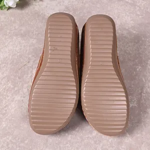 Close-up detail of the anti-slip ridged rubber sole on these brown women's wedge slippers