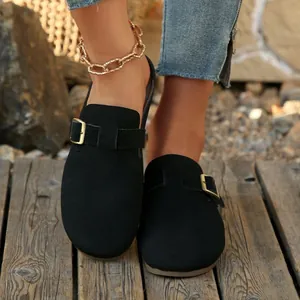 Detailed view of women's black suede round-toe flat mules with a vintage gold buckle