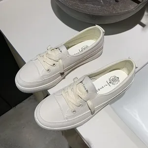 Detailed macro view of women's cream white casual sneakers with textured leather