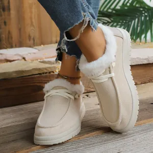 Close-up of women's beige winter snow boots with warm white faux fur lining.