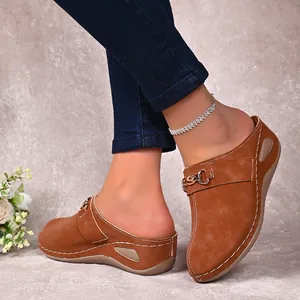 Detail view of brown wedge mules with buckle and contrast stitching for women.