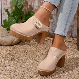 Close-up of beige platform mules with chunky high heels and metallic rivet details