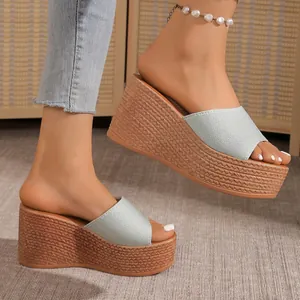 Détail de sandales compensées pailletées bleu clair pour femmes avec semelle tressée.