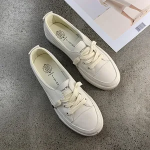 Close-up detail of stylish off-white minimalist women's casual sneakers on grey floor texture