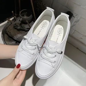 Stylish women's minimalist white sneakers with flat rubber soles and comfortable wide laces
