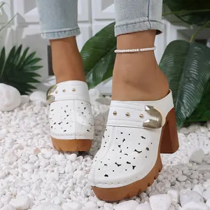 Close-up view of white hollow-out platform mules featuring metal buckle and thick brown heel
