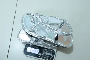 Silver braided flat toe-post sandals weighing 224.1g on a white electronic scale